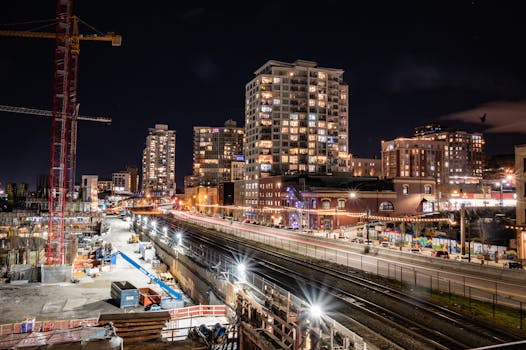 Illuminated construction site and cityscape of New Westminster, BC, Canada at night.